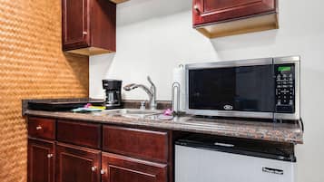 A compact kitchen with a microwave, coffee maker, and dishwasher.