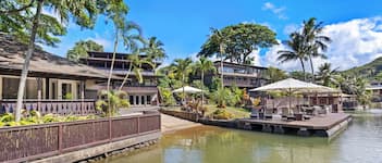 A resort with a pool, lounge chairs, and a wooden deck.