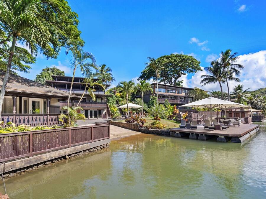 A resort with a pool, lounge chairs, and a wooden deck.