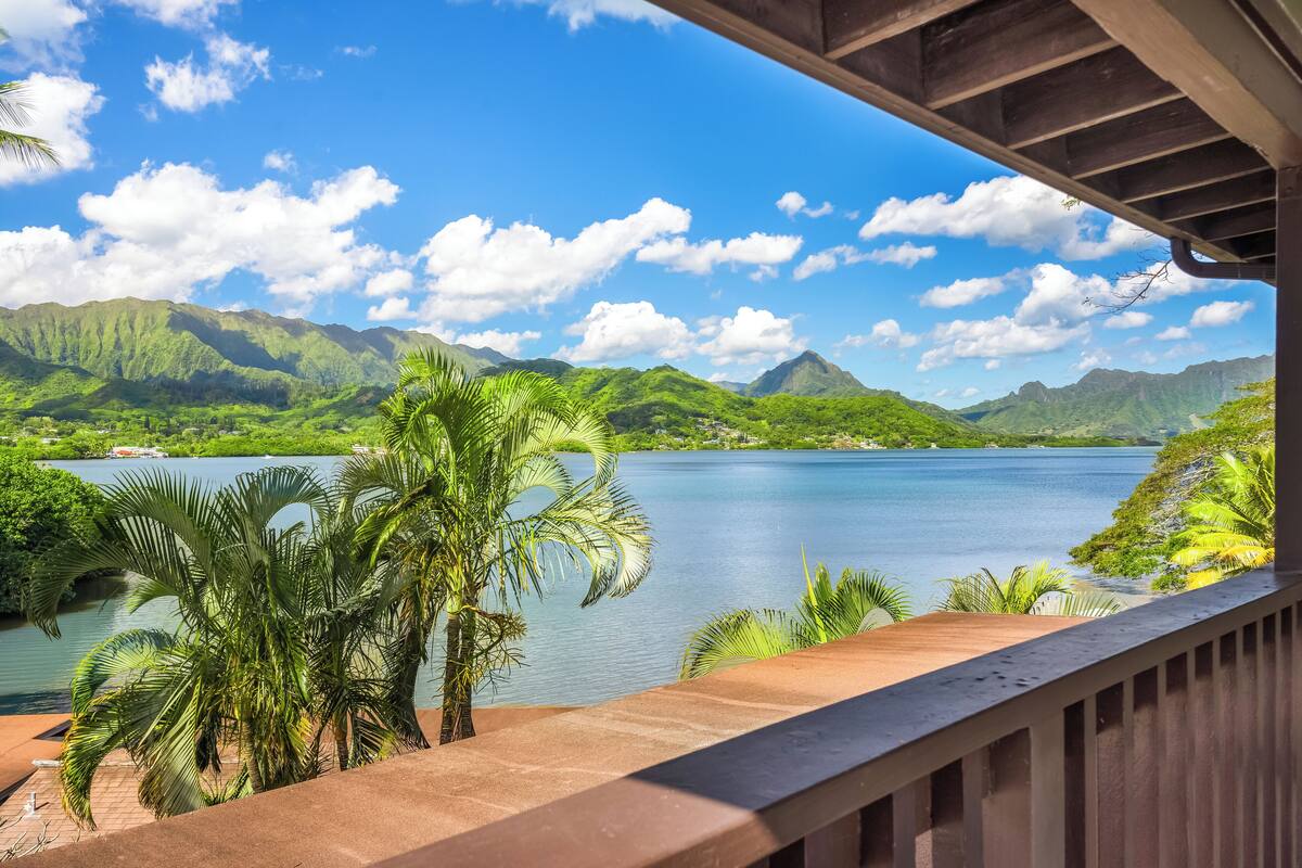 A view from a balcony overlooking a lake with mountains in the background.