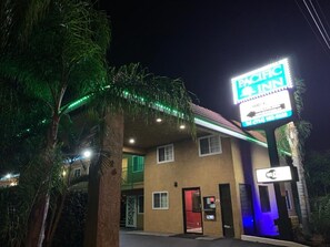 A Pacific Inn hotel with a neon sign, a visible entrance, and a palm tree in the foreground. - Pacific Inn Anaheim (Anaheim)