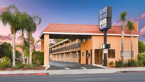 A Pacific Inn hotel with a red-tiled roof, multiple balconies, and a sign indicating WiFi availability. - Pacific Inn Anaheim (Anaheim)