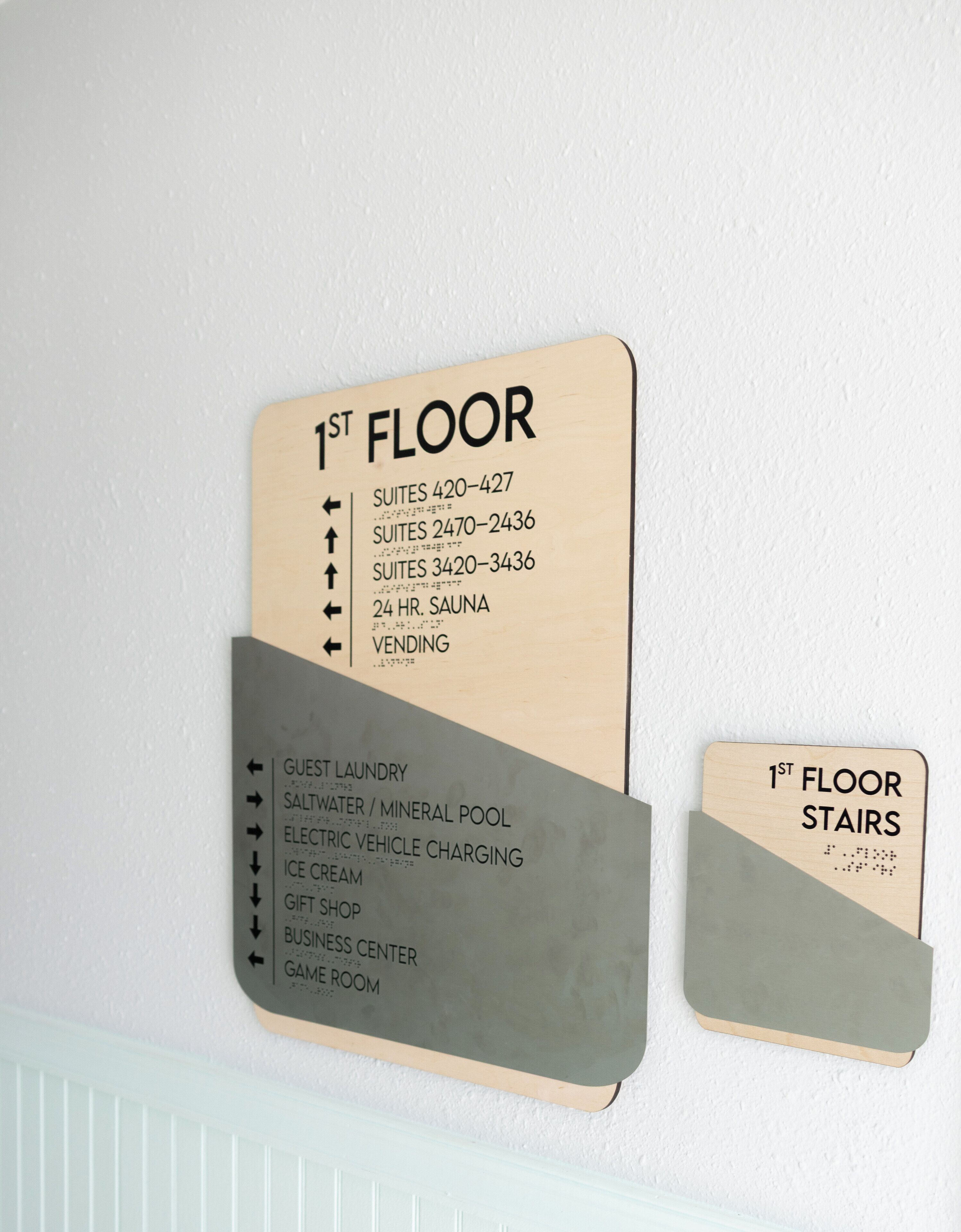 A hotel floor sign listing amenities like guest laundry, saltwater/mineral pool, and a game room.