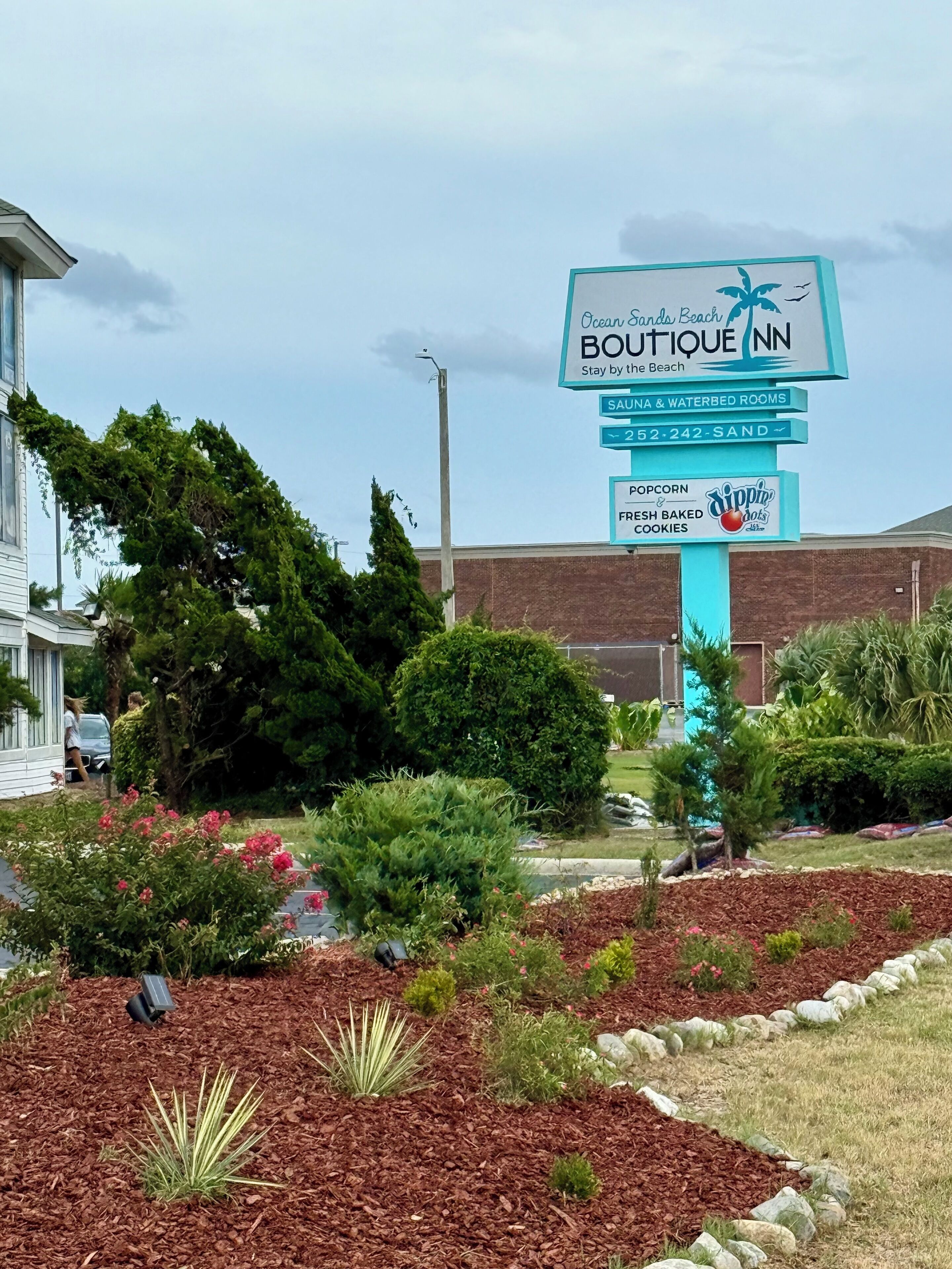 A sign for Boutique Inn with amenities like saunas, waterbeds, popcorn, and baked cookies.