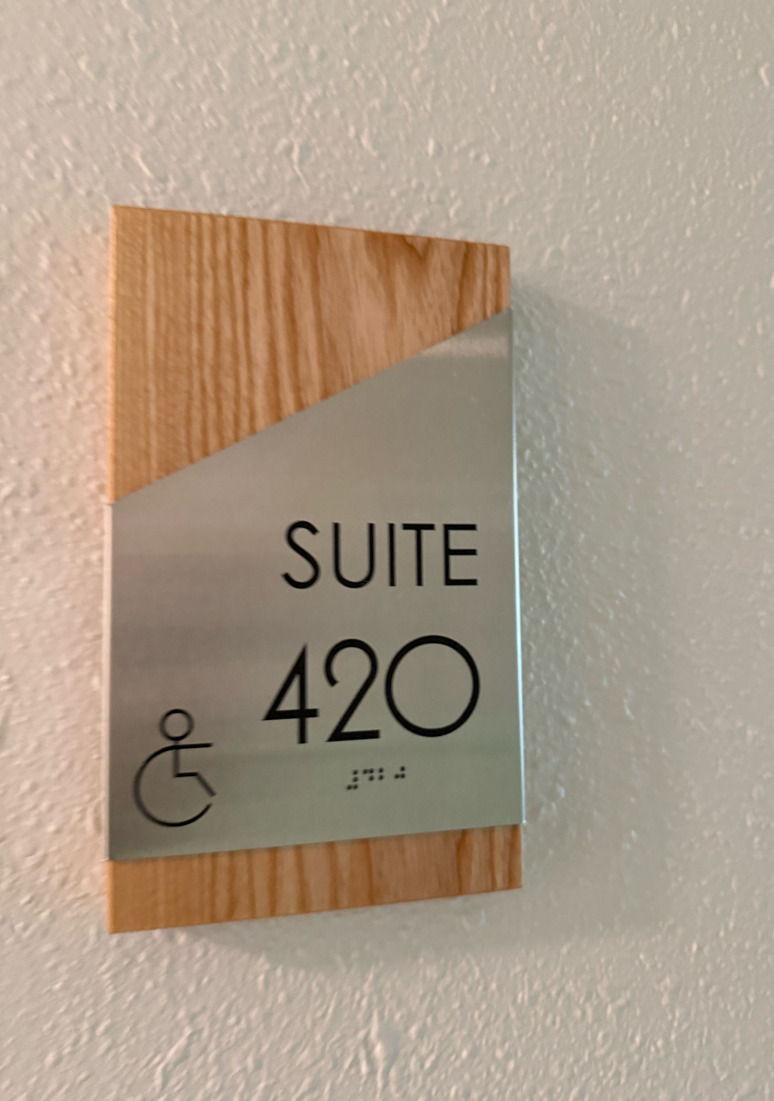 Señal que indica 'Suite 420' con símbolo de accesibilidad para sillas de ruedas.