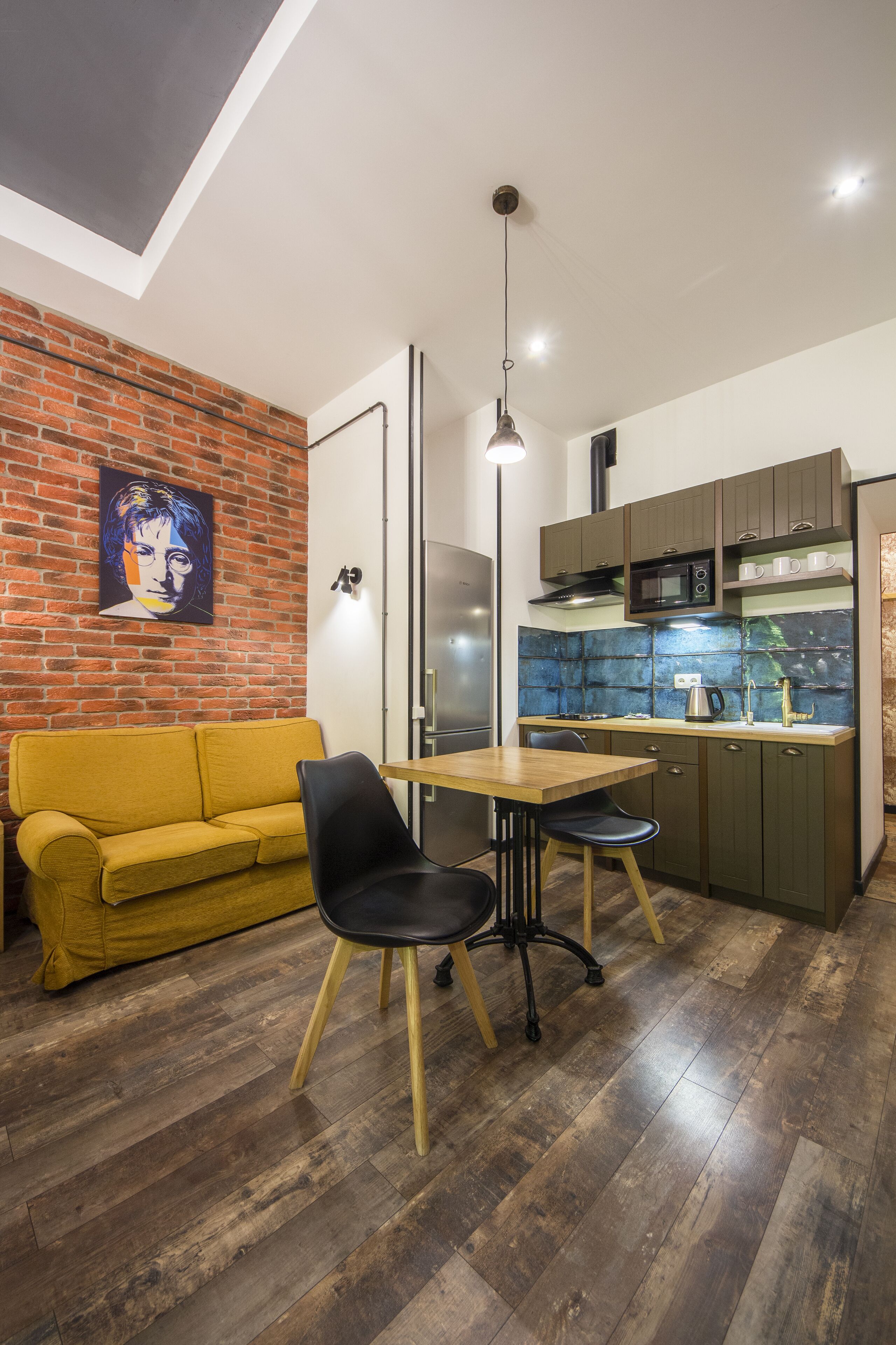 Un espace de vie compact comprenant un coin repas, une kitchenette et un canapé.