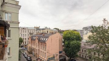 Une vue de rue avec des voitures garées, des immeubles et un arbre.