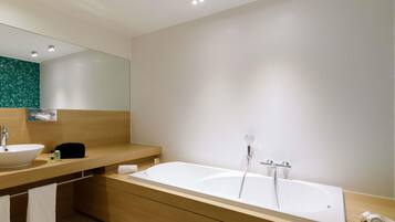 Een moderne badkamer met een vrijstaand bad, een wastafelmeubel en een spiegel.