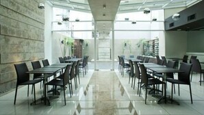 Una sala de conferencias moderna con paredes de vidrio, un pasillo central y vistas al exterior.