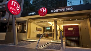 Fachada de hotel de diseño moderno, con vidrio, una recepción y una pantalla digital.