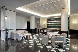 A modern lobby with a central seating area, a large wall-mounted aquarium, and a polished floor. - Ganjiang Hotel (Nanchang)