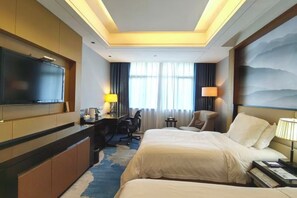 A hotel room with a bed, desk, chair, TV, and a view of the outdoors.