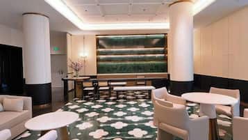 A lobby with a seating area, a reception desk, and a decorative wall.