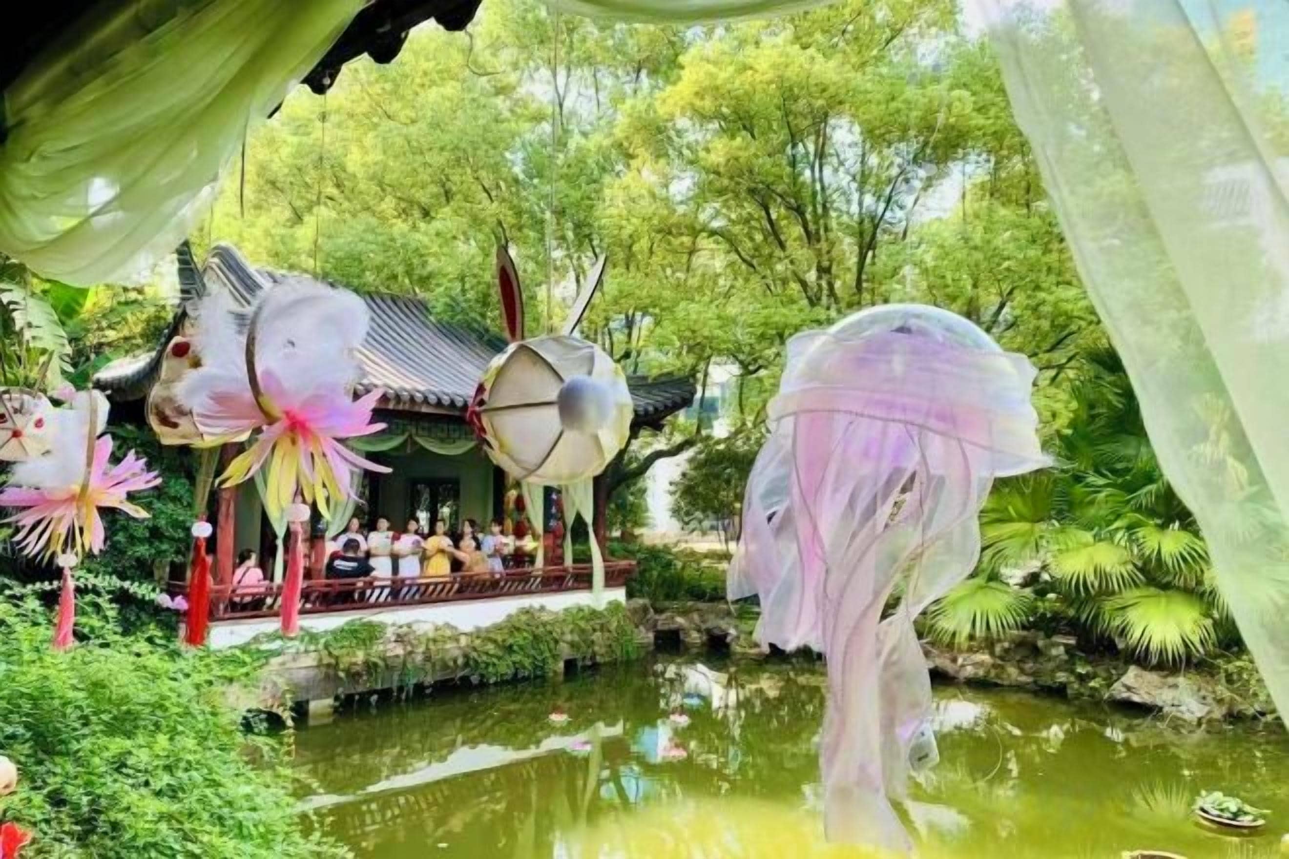 Ein traditioneller Pavillon mit Teich, umgeben von üppigem Grün.