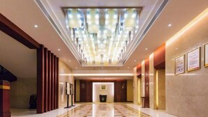 A hotel lobby with a high ceiling, a patterned floor, and a central light fixture. - Ganjiang Hotel (Nanchang)