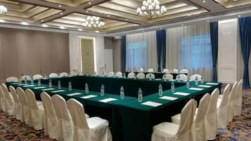 A conference room with a long table, white chairs, and water bottles.