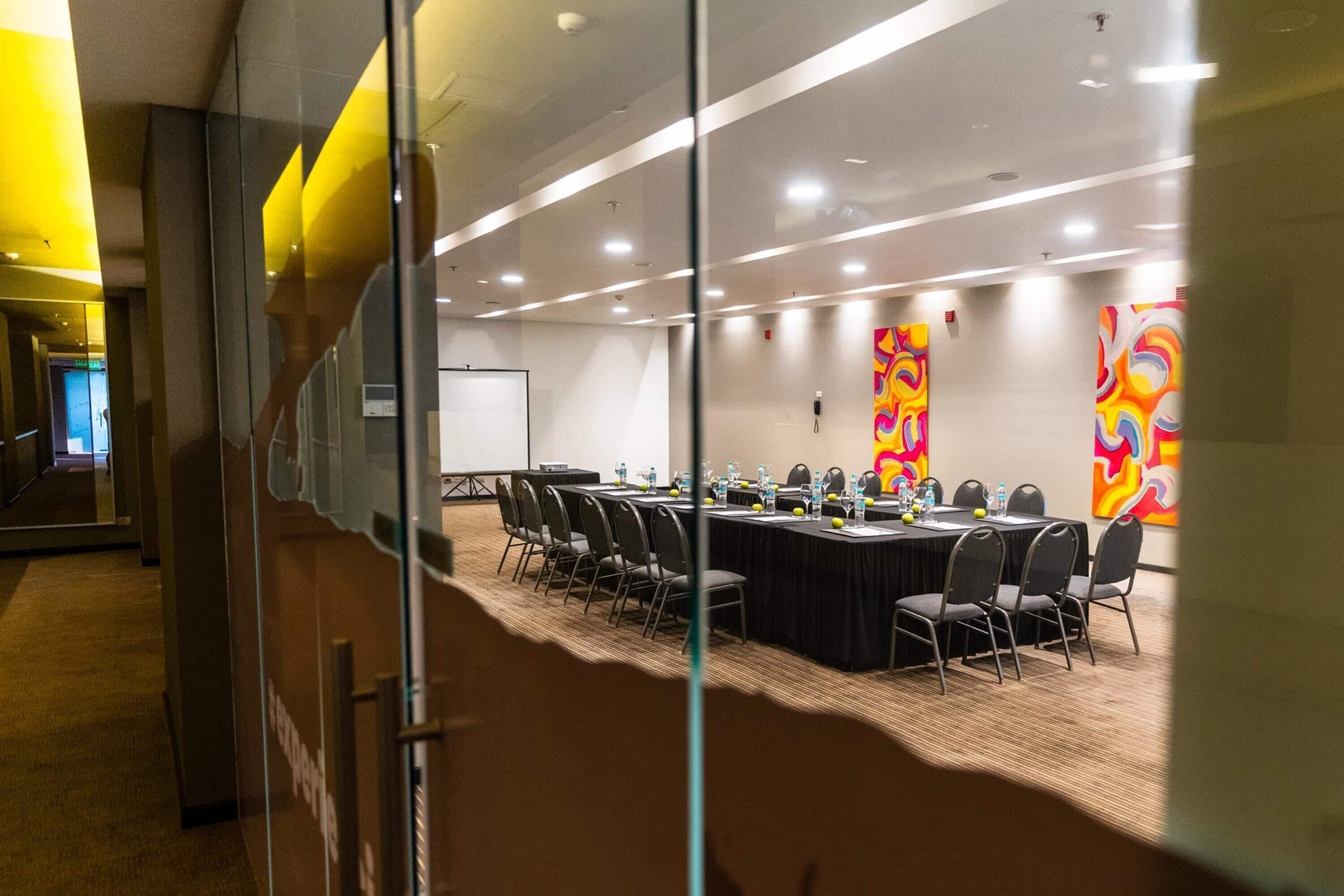 A conference room with a long table, chairs, and a whiteboard.