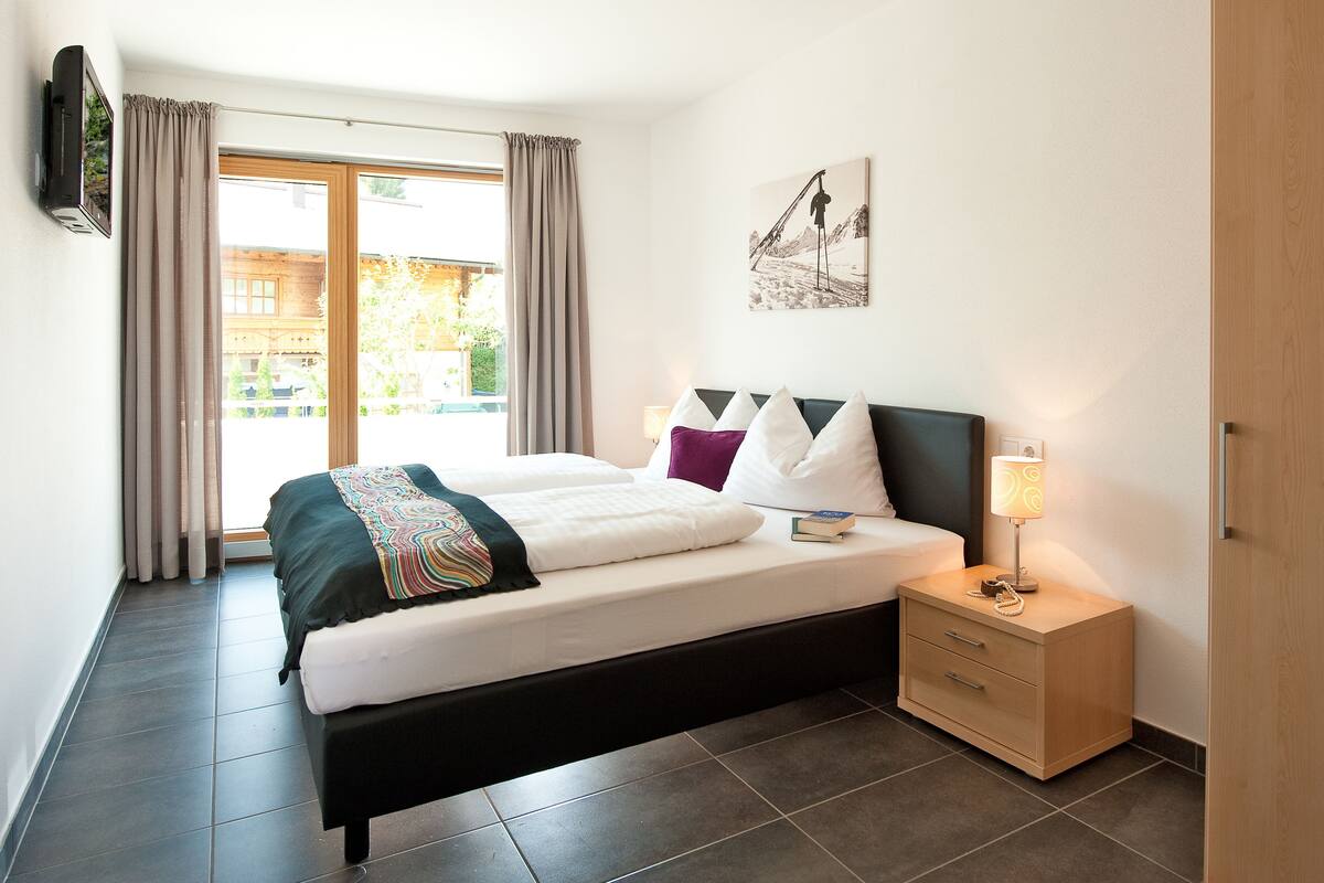 Ein Hotelzimmer mit Bett, Nachttisch, Lampe und einem Bild an der Wand.