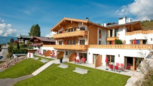 Ein mehrstöckiges Hotel mit Balkon, Außenbereich und gepflegtem Rasen.