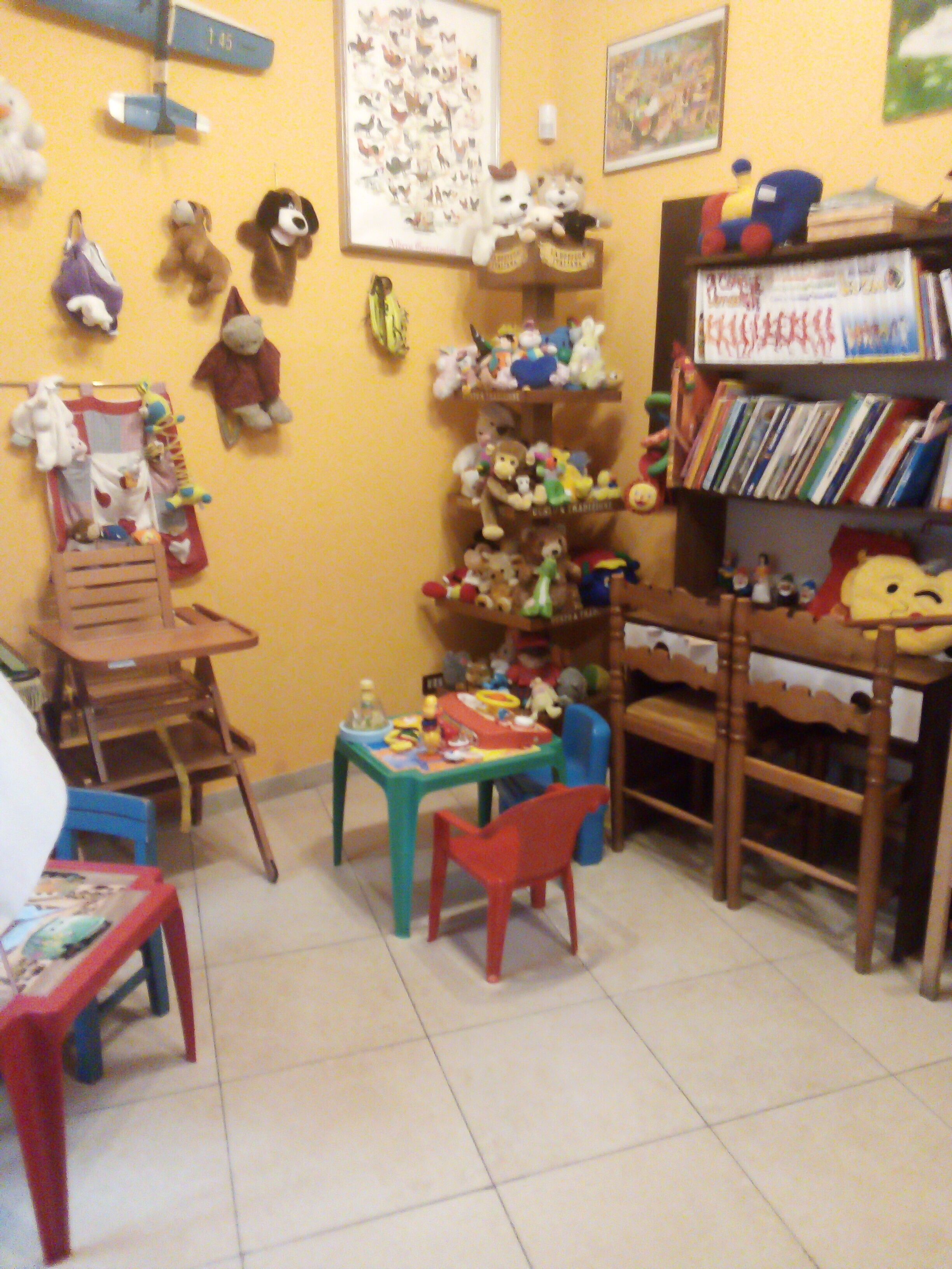 A room with a wooden bookshelf, a small table, and a chair.