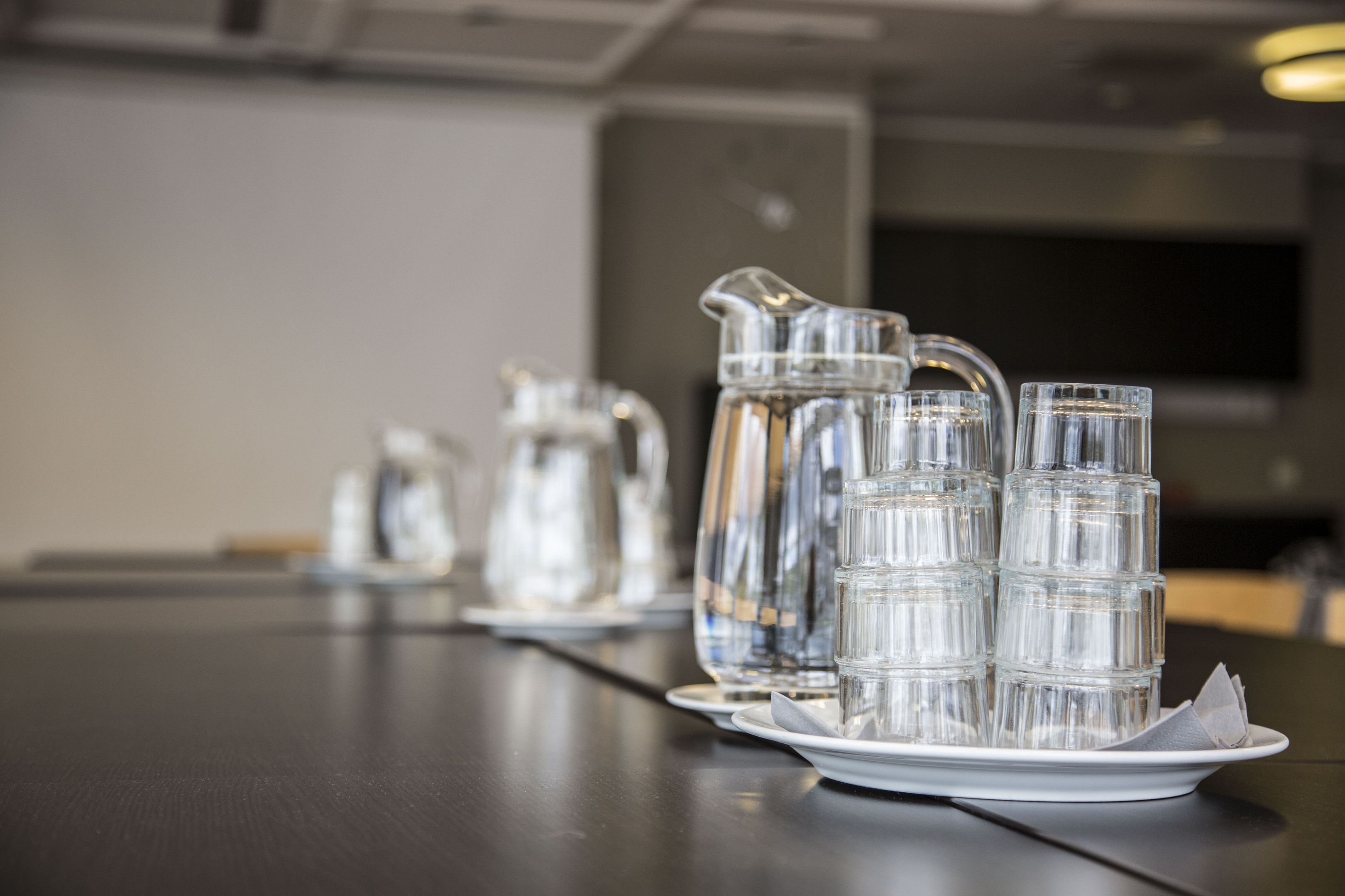A table with a pitcher, glasses, and a plate.