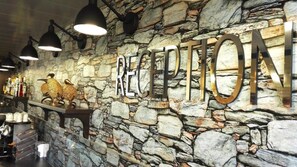 A reception area with a stone wall and a large 'RECEPTION' sign.
