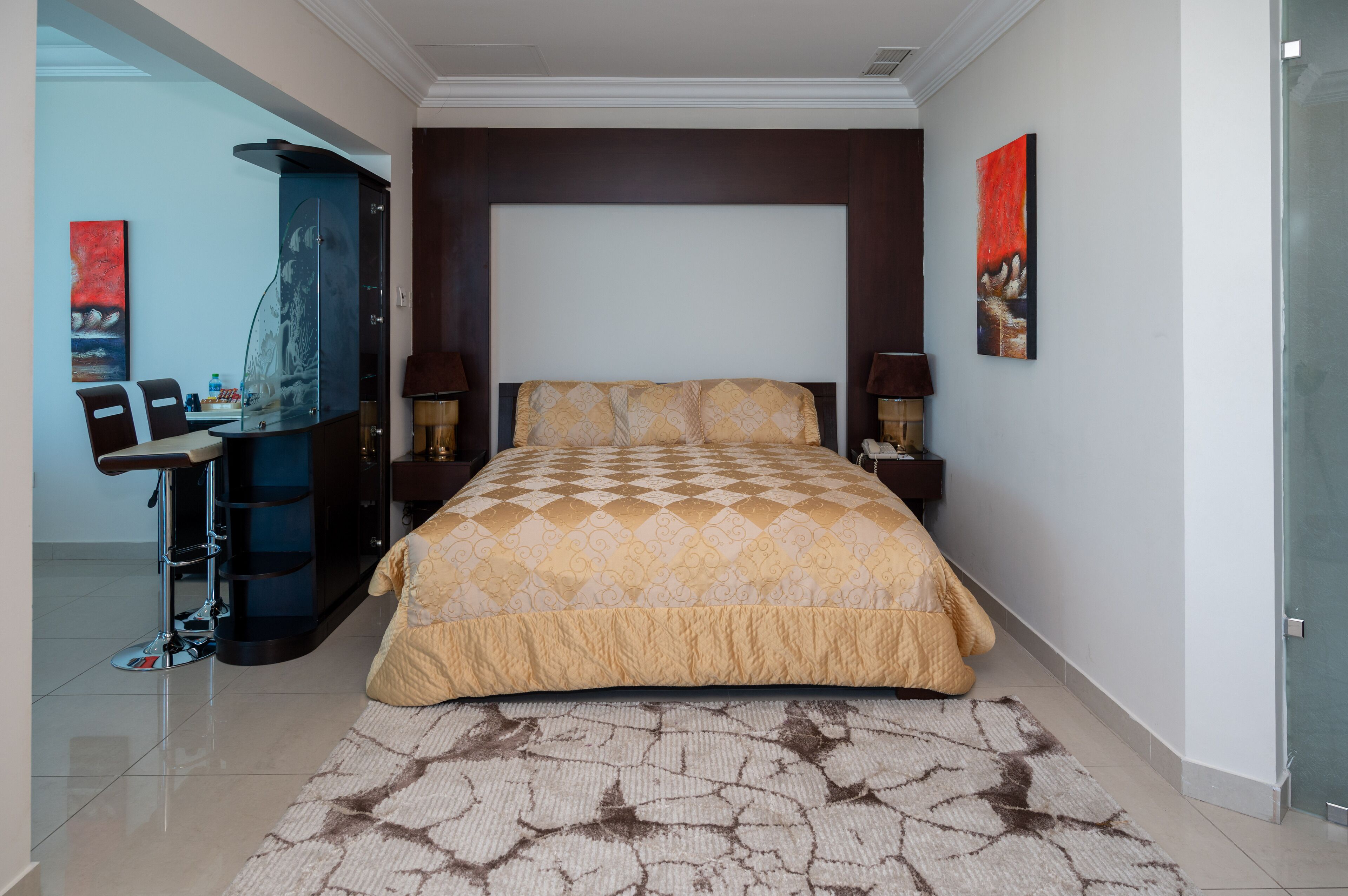 Una camera da letto moderna con un letto grande, una scrivania con una sedia e una cabina doccia in vetro.