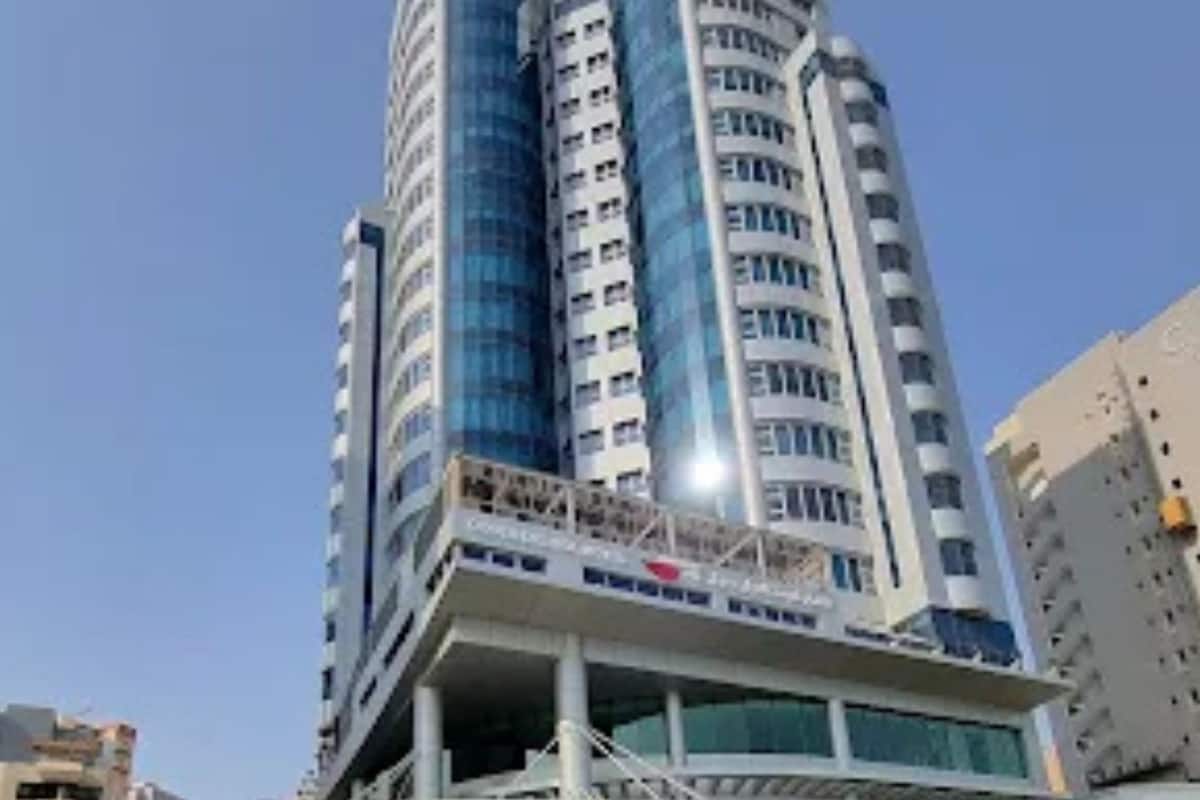 Un hôtel moderne doté de deux tours cylindriques, d’un atrium central et d’une fontaine en premier plan.
