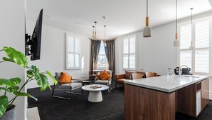 Una sala de estar moderna con una isla central, sofás grises y una mesa de centro.