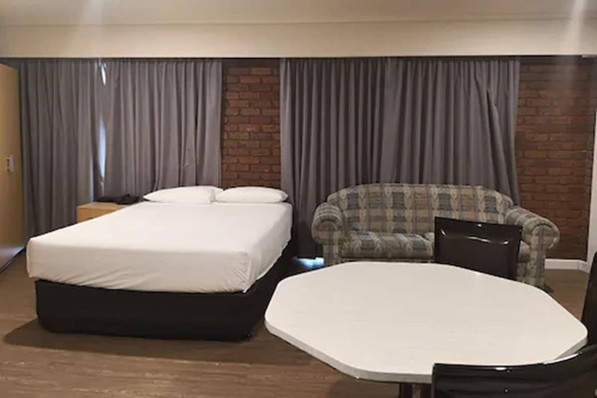 Ein Hotelzimmer mit Bett, Sofa und einem kleinen Tisch.