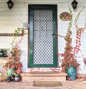 Welcome to a charming entrance with a diamond-patterned glass panel, reception sign, and decorative vines.