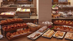 Ein Buffet mit verschiedenen Backwaren und Desserts, darunter Croissants, Kleinen und anderen Gebäck.