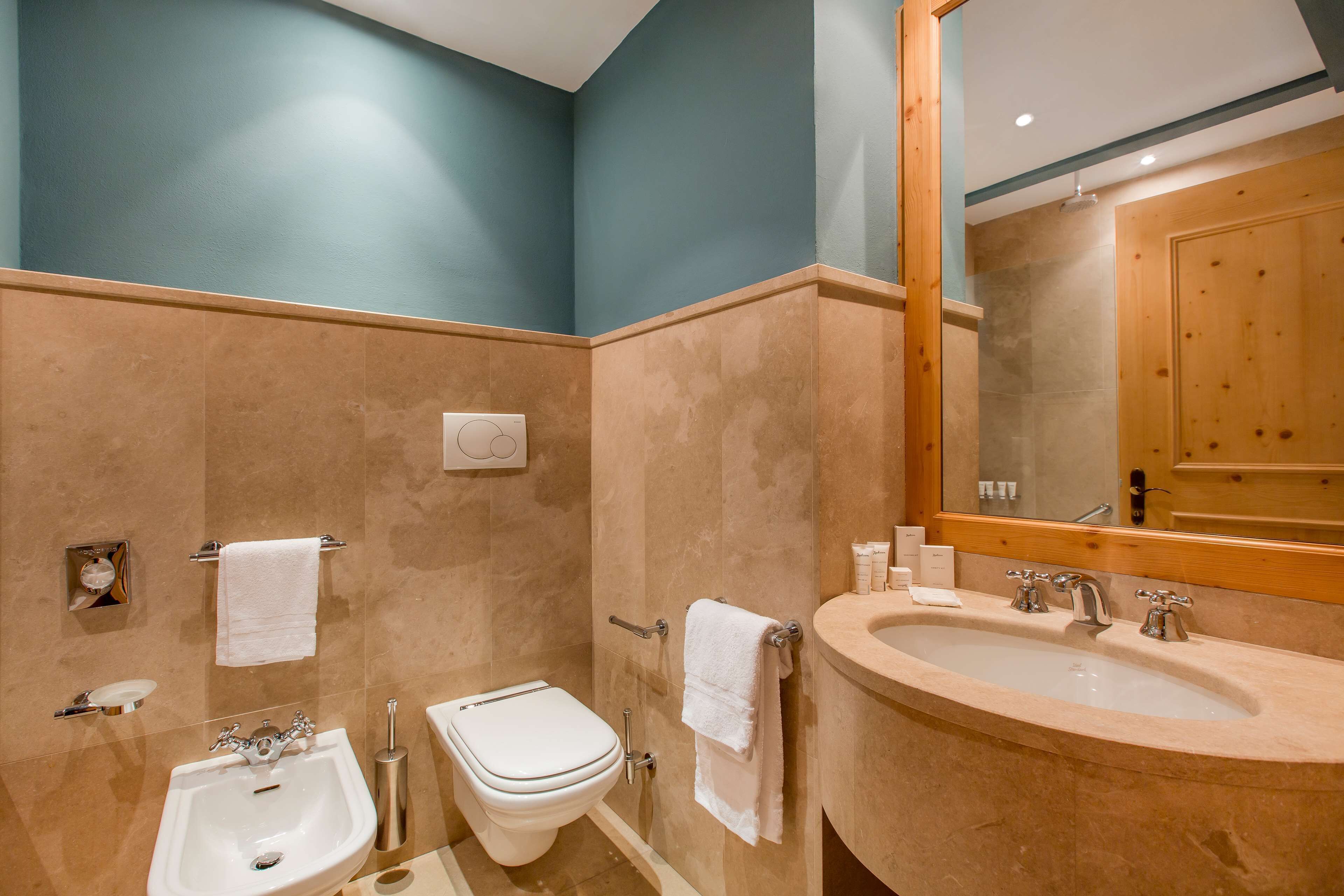 A bathroom with a sink, toilet, and shower.