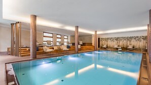 Una piscina interior con zona de estar y vistas a la ciudad.