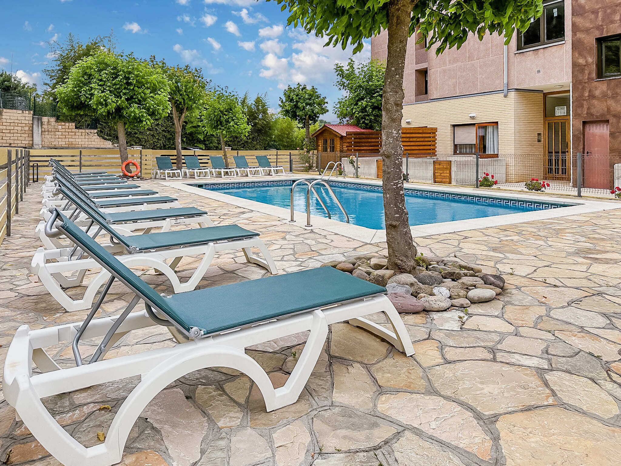 Zona de piscina amb gandules i una piscina.