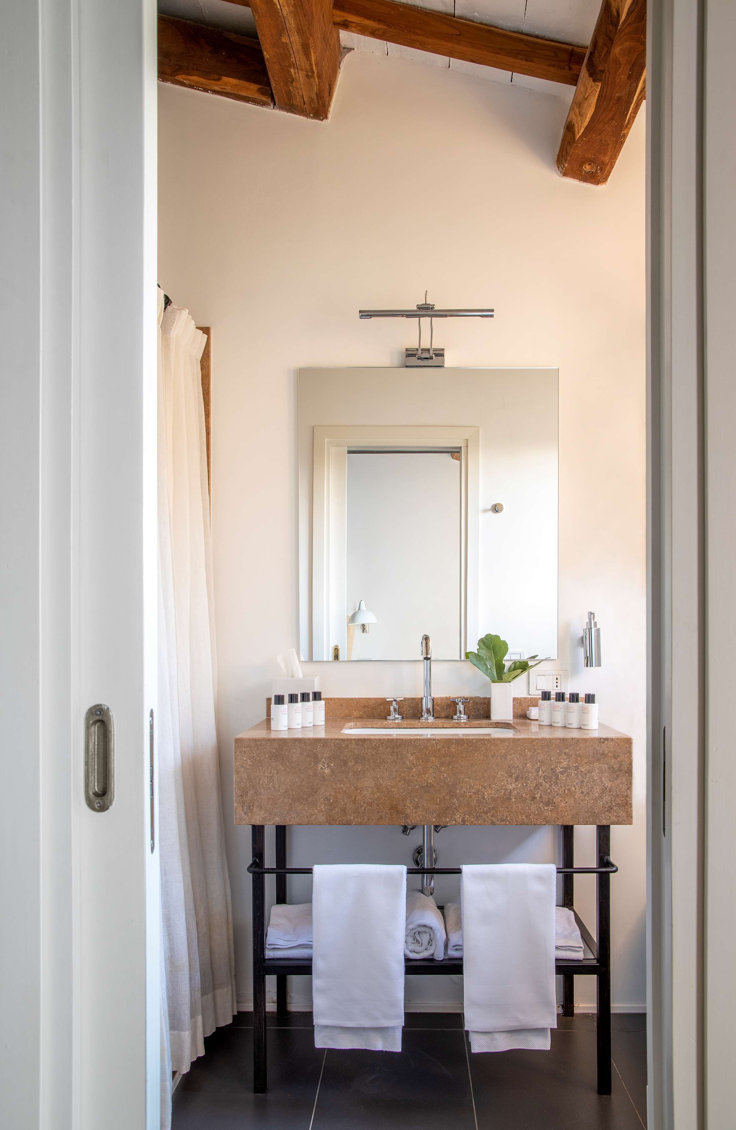 A bathroom with a double sink, a large mirror, a towel rack, and a shower curtain.