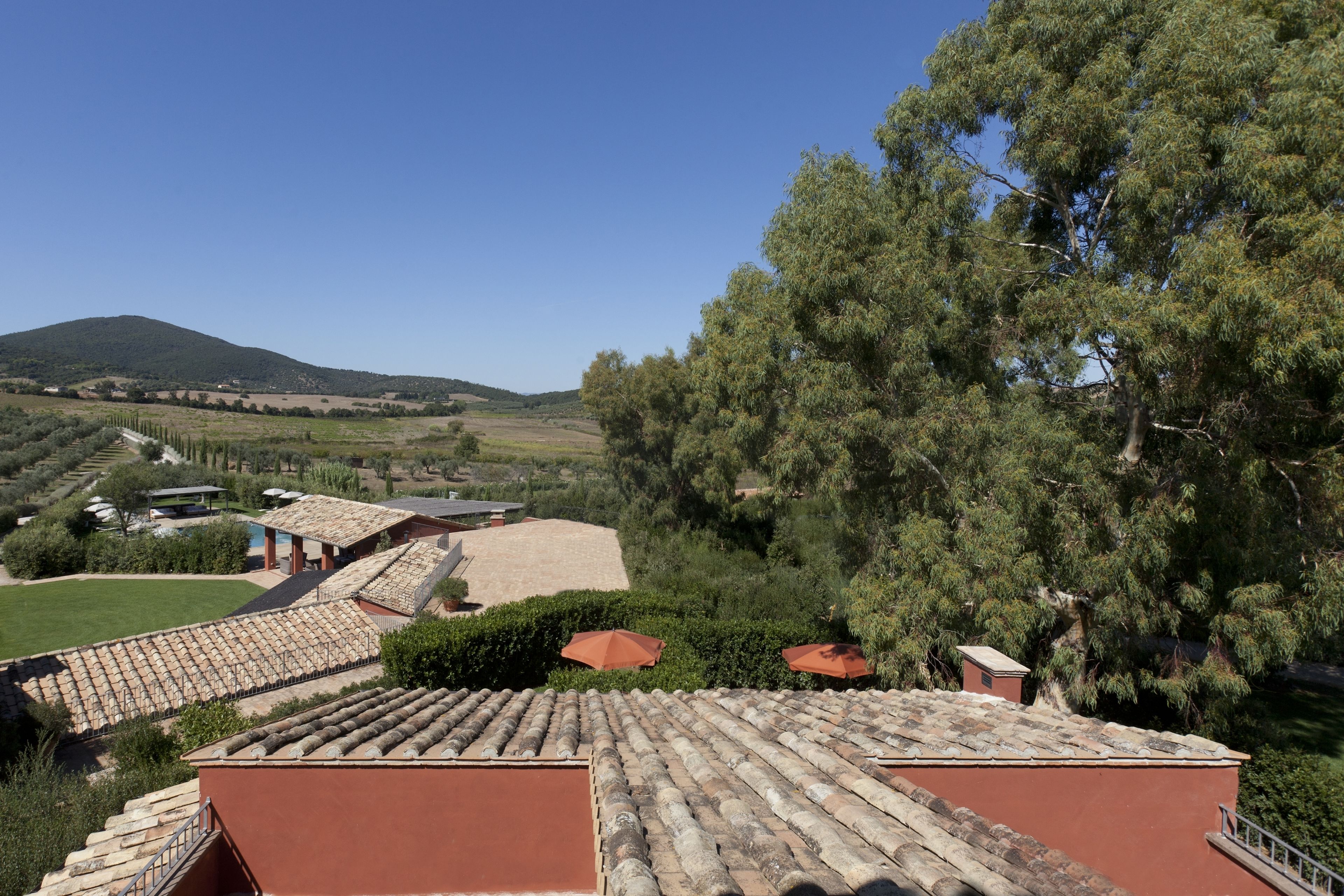 Eine Villa mit Terrakotta-Dachziegeln, einem Swimmingpool und Blick auf die Landschaft.