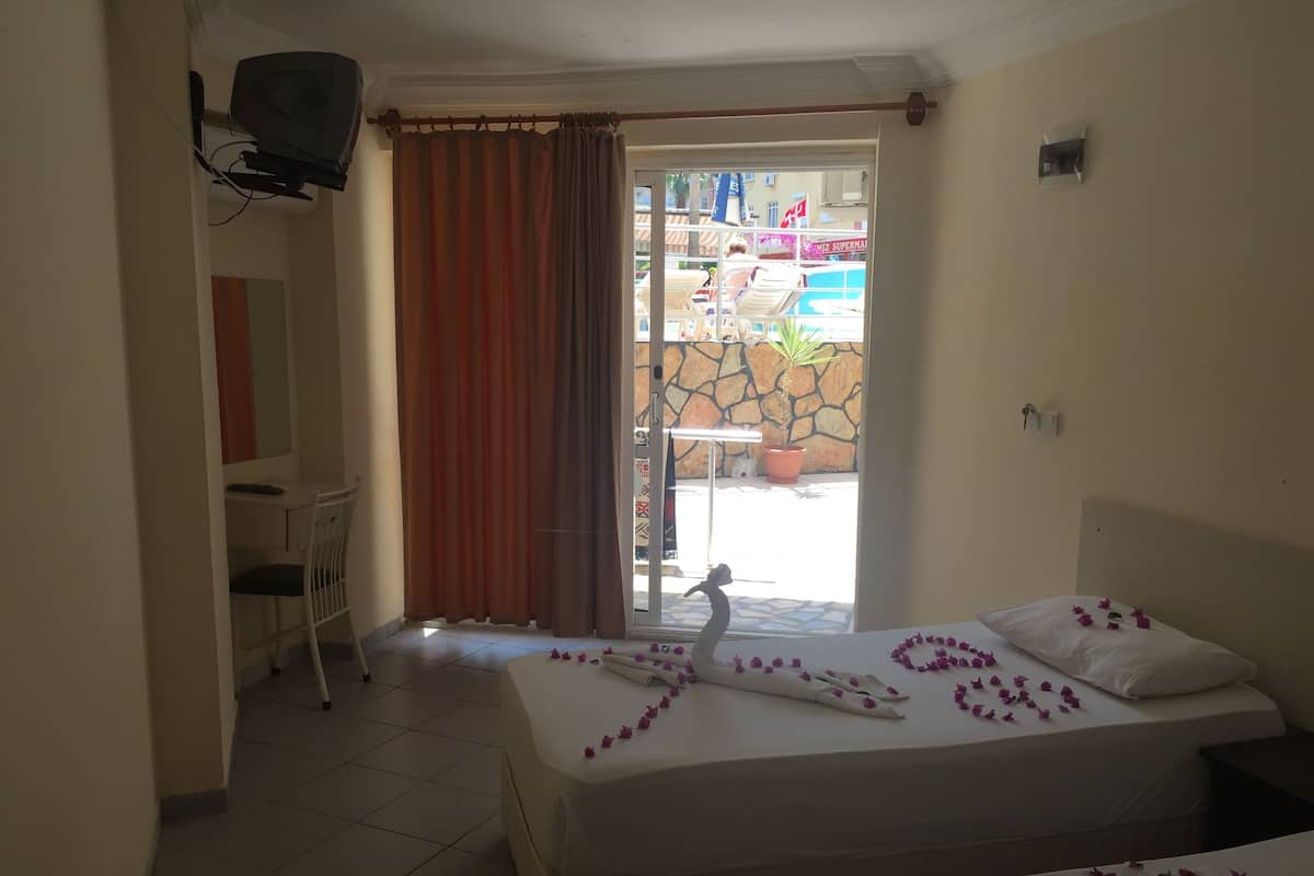 A hotel room with a bed, a desk, and a chair.