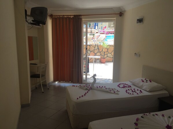 A hotel room with a bed, a desk, and a chair.