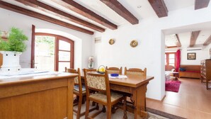 A dining area with wooden furniture, a potted plant, and a window with a view. - Dubrovnik Center Apartments (Dubrovnik)