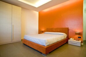 A bedroom with a bed, nightstand, and wardrobe.
