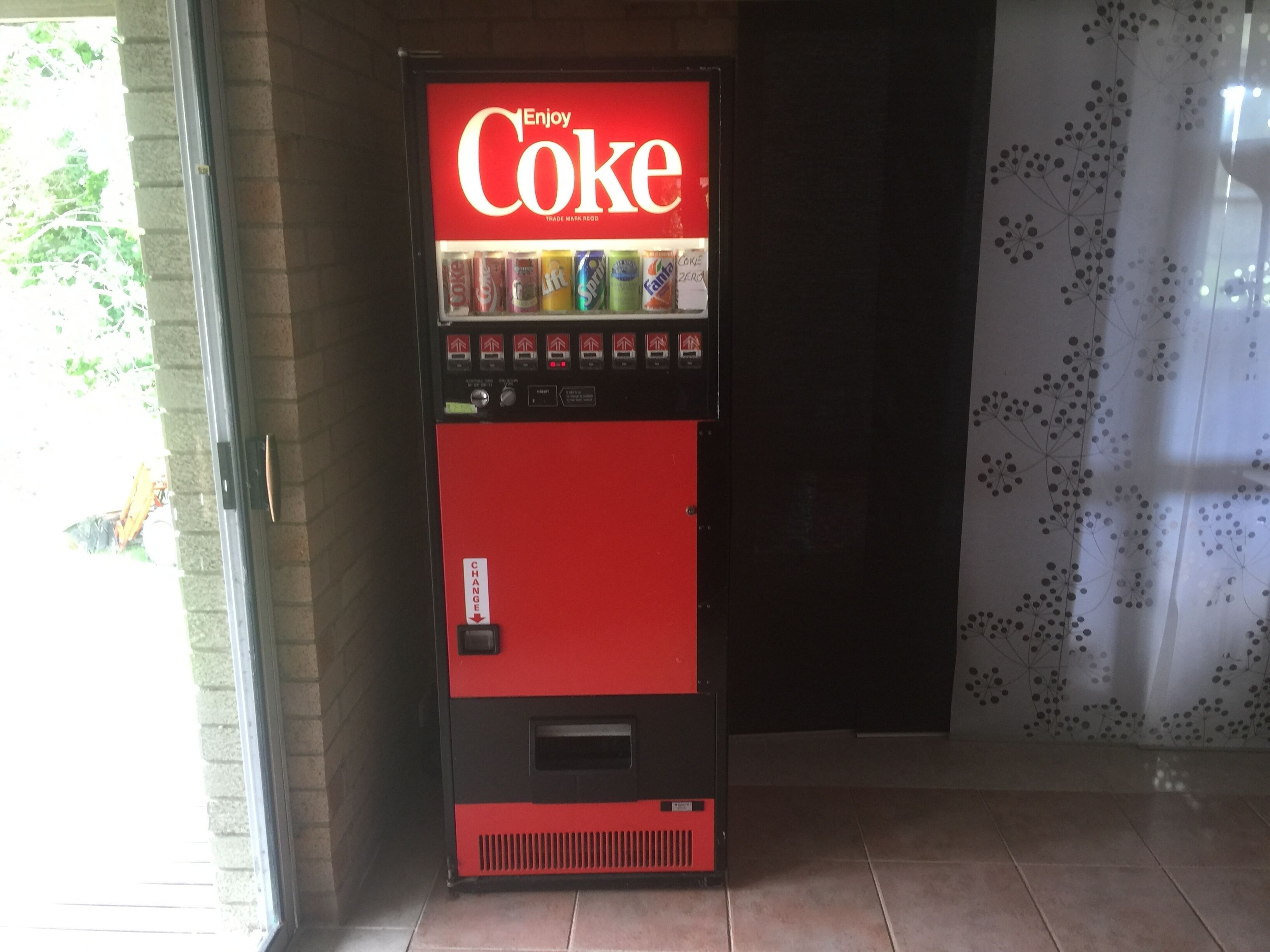 Máquina expendedora con diseño rojo y negro, etiquetada con 