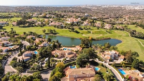 Un quartier résidentiel avec des maisons, un terrain de golf et un lac.