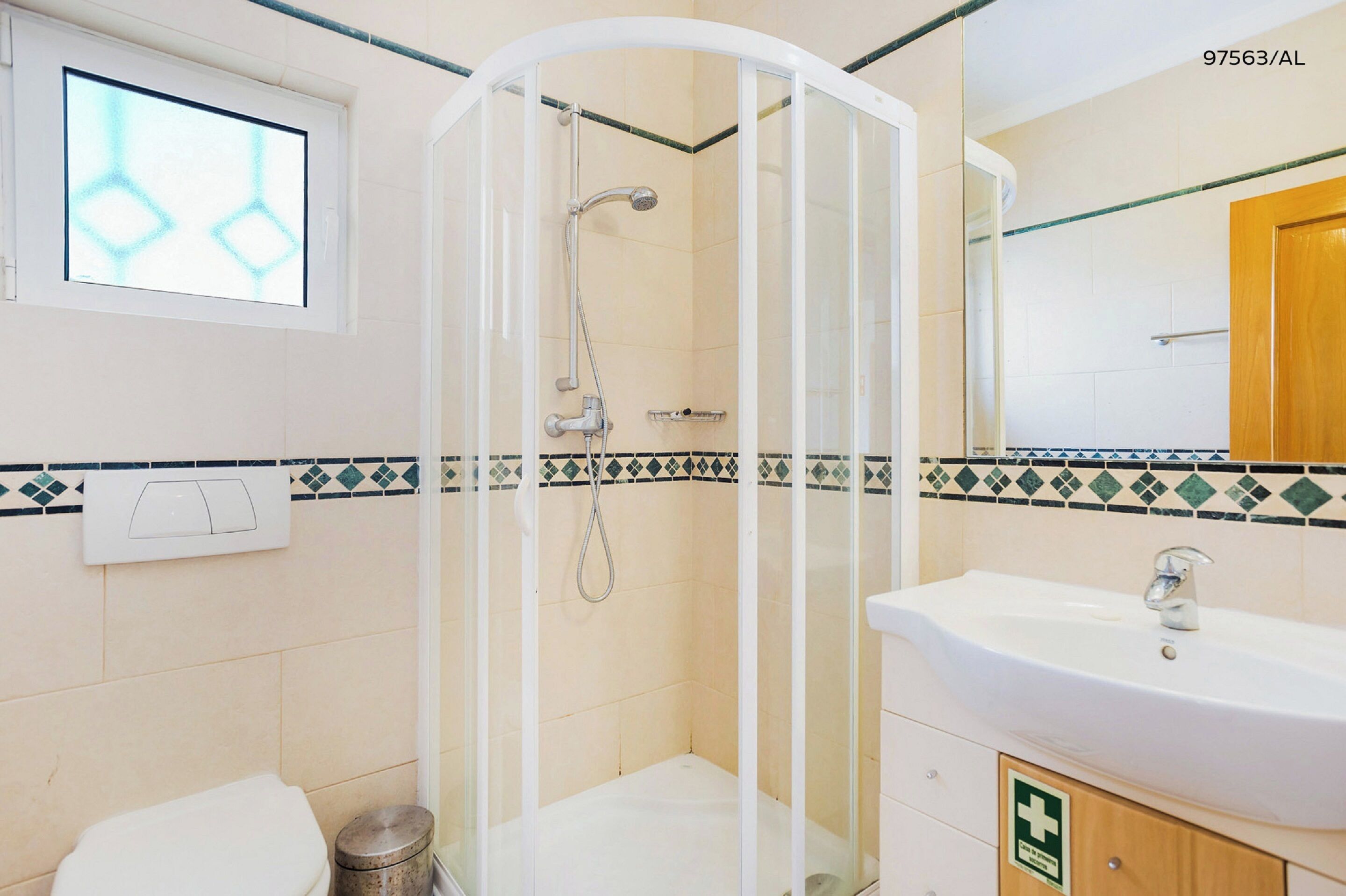 Une salle de bain avec une douche à parois de verre, un lavabo et des toilettes.