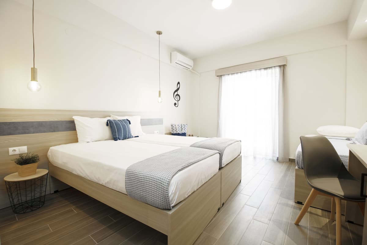 Una habitación de hotel moderna con una cama grande, mesitas de noche, un escritorio y una silla.