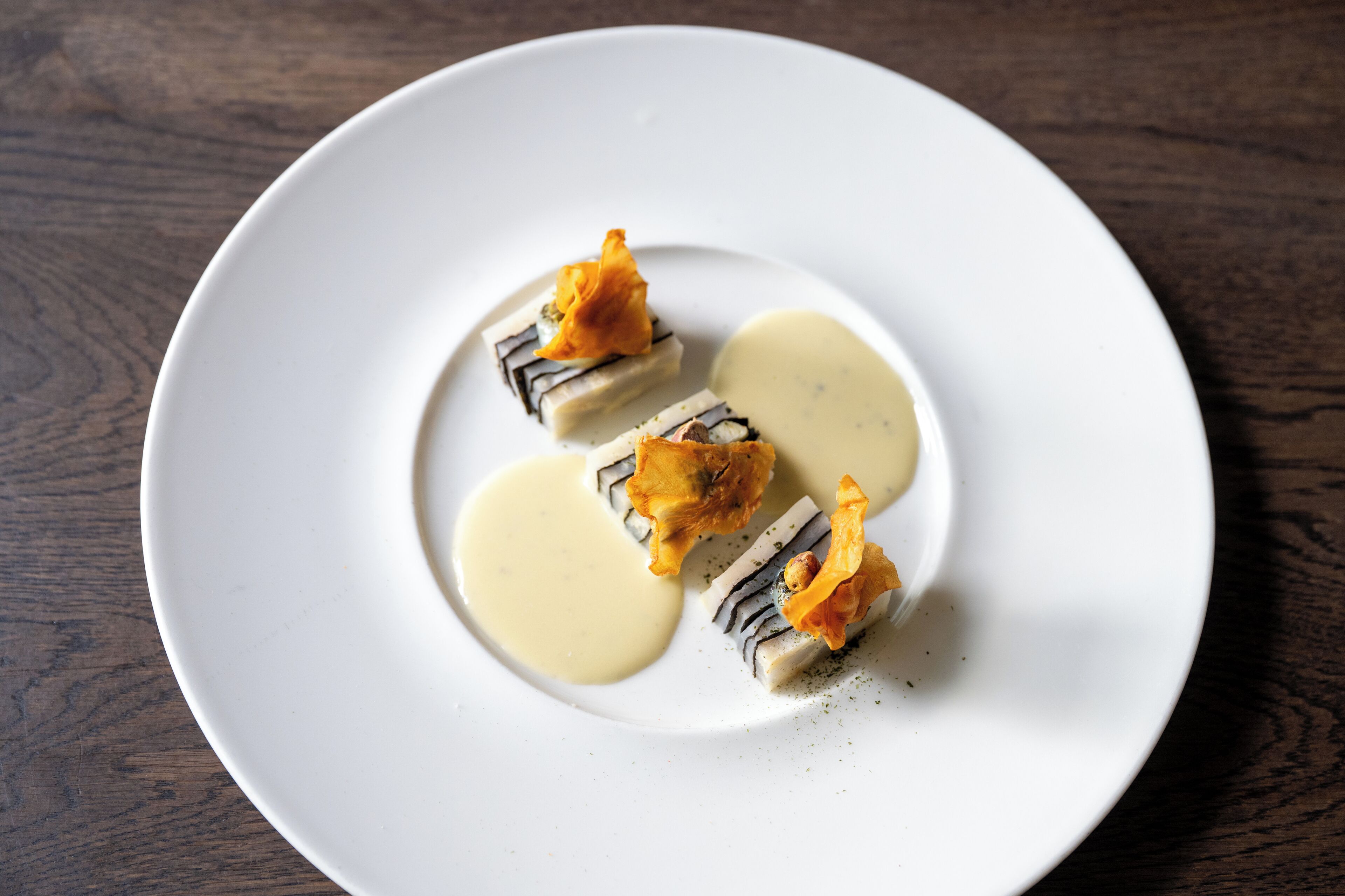A white plate with food on a wooden table.