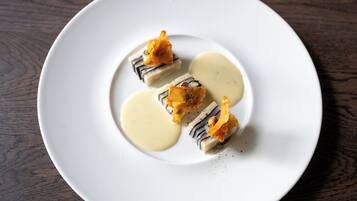A white plate with food on a wooden table.