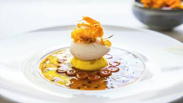 A dessert on a white plate with a clear liquid and caramelized sugar rings around it.