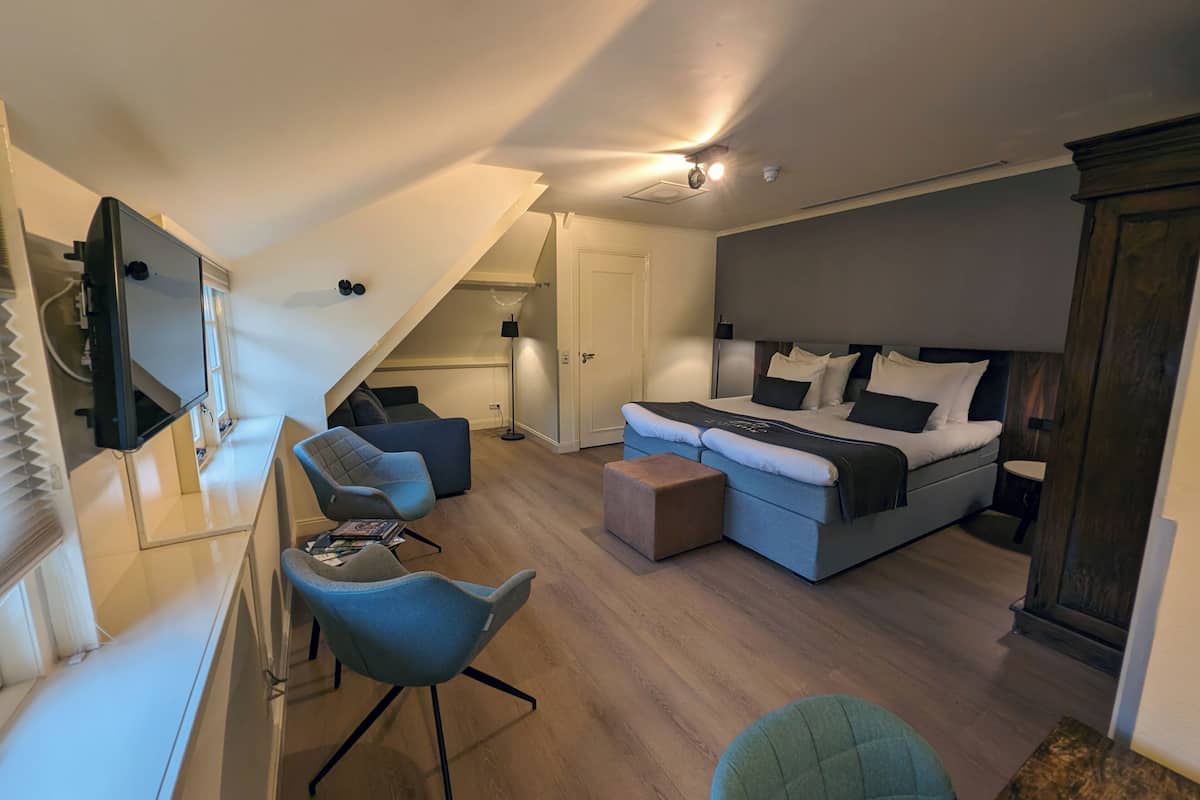 A modern bedroom with a bed, a desk, and a chair.