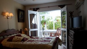 A bedroom with a large bed, a television, a chair, and a dresser. - La Casona de Susana (Colon)